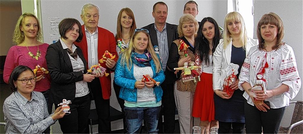 Ukrainische Sozialarbeiterinnen und -arbeiter mit Puppen, die Kinder in ihrer Heimat gebastelt haben – zum Beispiel als Glücksbringer für Soldaten. Mit auf dem Bild: Professor Dr. Walther Specht (3. Stehender v. li.) und Natascha Zöller (stehend links), beide von ISMO, sowie Elena Schwegler von der Mobilen Jugendarbeit (4. Stehende v. li.). Foto: Sadler