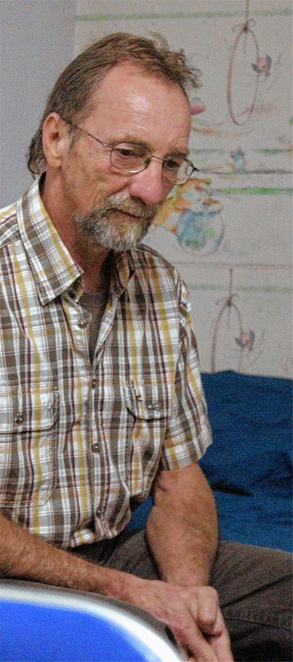 Ulrich Noller sitzt in der Unterkunft auf dem leeren Bett des Gambiers Momodu. 