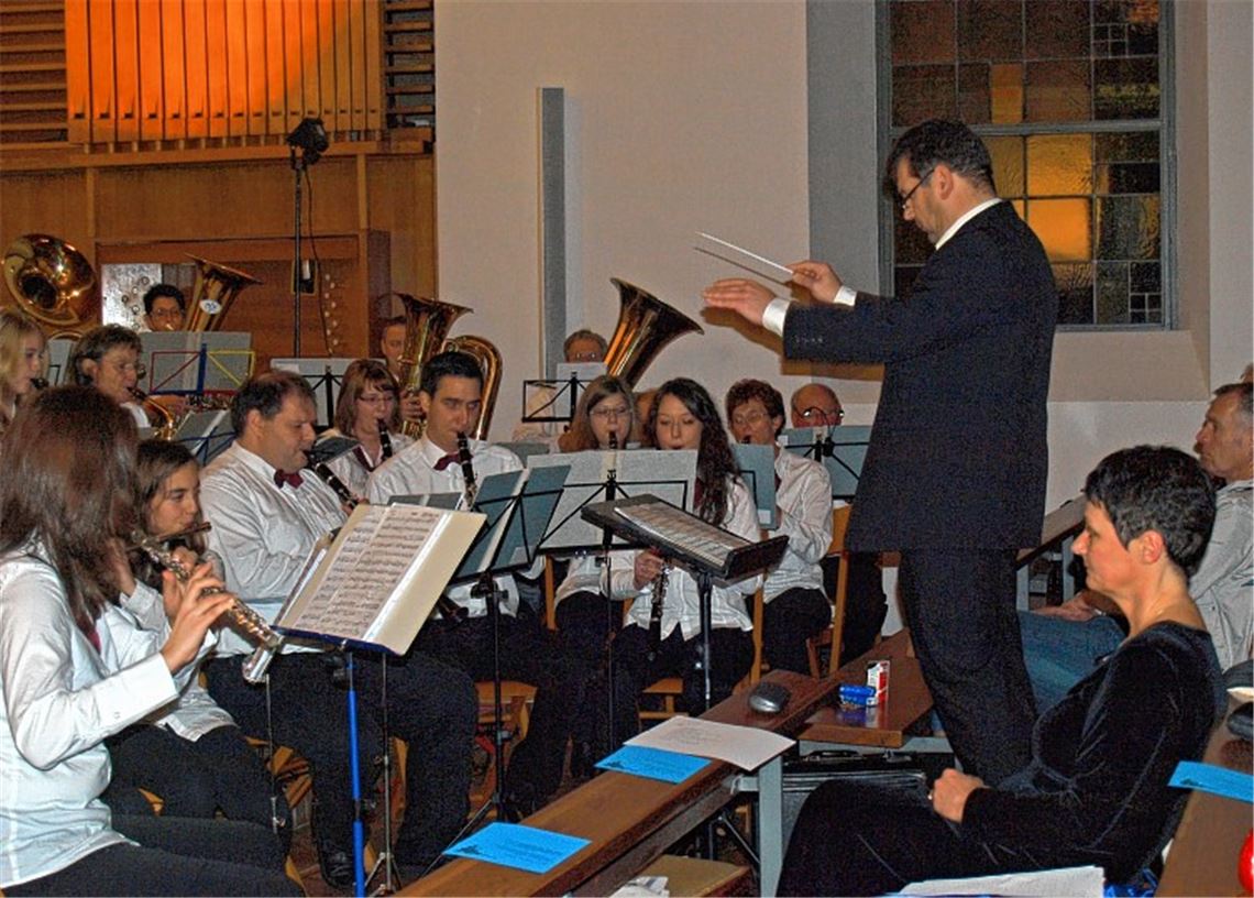 Ulrich Seibold dirigiert seine Musiker bei einem weihnachtlichen Konzert in der Kirche. Foto: Filitz