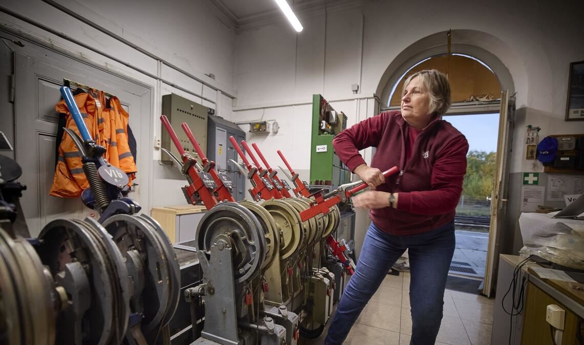 Ulrike Frese legt mit Schwung den roten Hebel für das Ausfahrtssignal um.