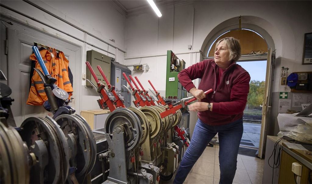 Ulrike Frese legt mit Schwung den roten Hebel für das Ausfahrtssignal um.