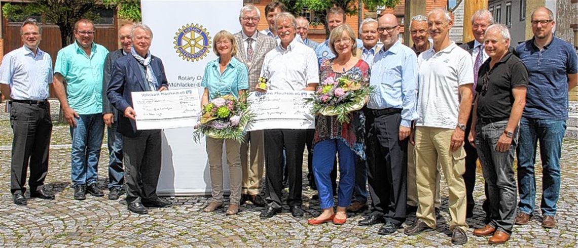 Umrahmt von den Mitgliedern des Rotary Clubs Mühlacker-Enzkreis nehmen Karin Eckstein (5. v. li.) und Angelika Miko Schecks für das Projekt Familienherberge Lebensweg in Empfang.