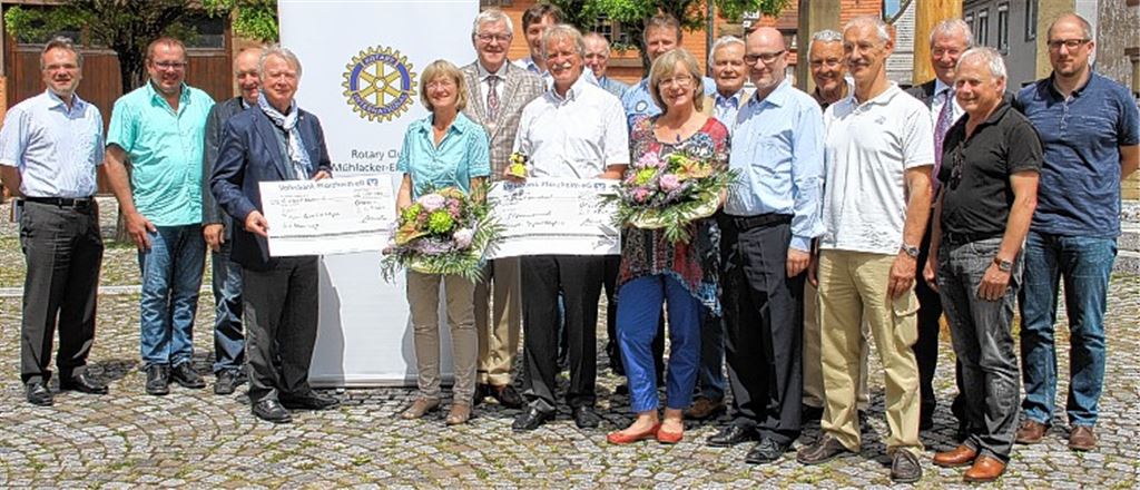 Umrahmt von den Mitgliedern des Rotary Clubs Mühlacker-Enzkreis nehmen Karin Eckstein (5. v. li.) und Angelika Miko Schecks für das Projekt Familienherberge Lebensweg in Empfang.