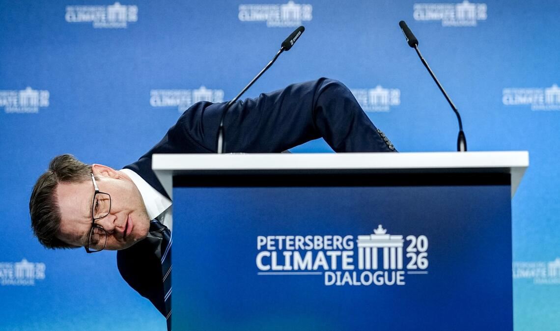 Umweltminister Carsten Schneider (SPD) beugt sich beim 17. Petersberger Klimadialog neben das Pult.