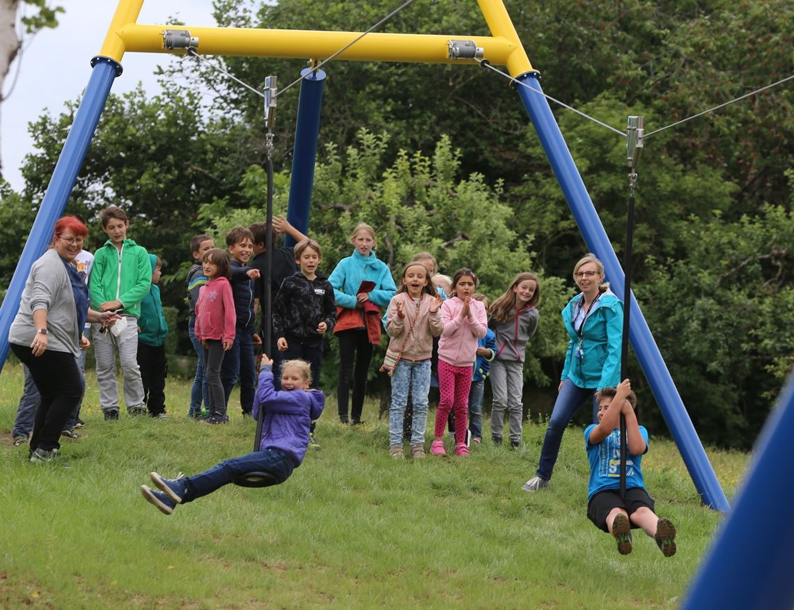Erfolgreicher Auftakt für neues Spielgerät Und ab geht die Post: Die Kernzeit-Kinder der Grundschule Schützingen und Izabel Fritsch (li.), die Leiterin der Kernzeitbetreuung, haben Spaß beim Ausprobieren der neuen Seilrutsche. Foto: Willimek
