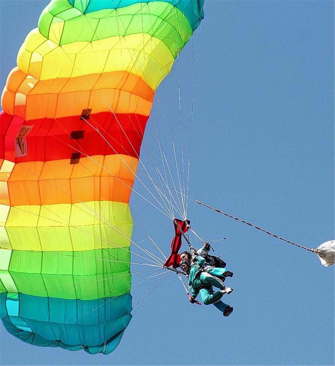Unterm regenbogenfarbenen Schirm gleiten die beiden Tandemspringer sicher zu Boden.Fotos: Kollros