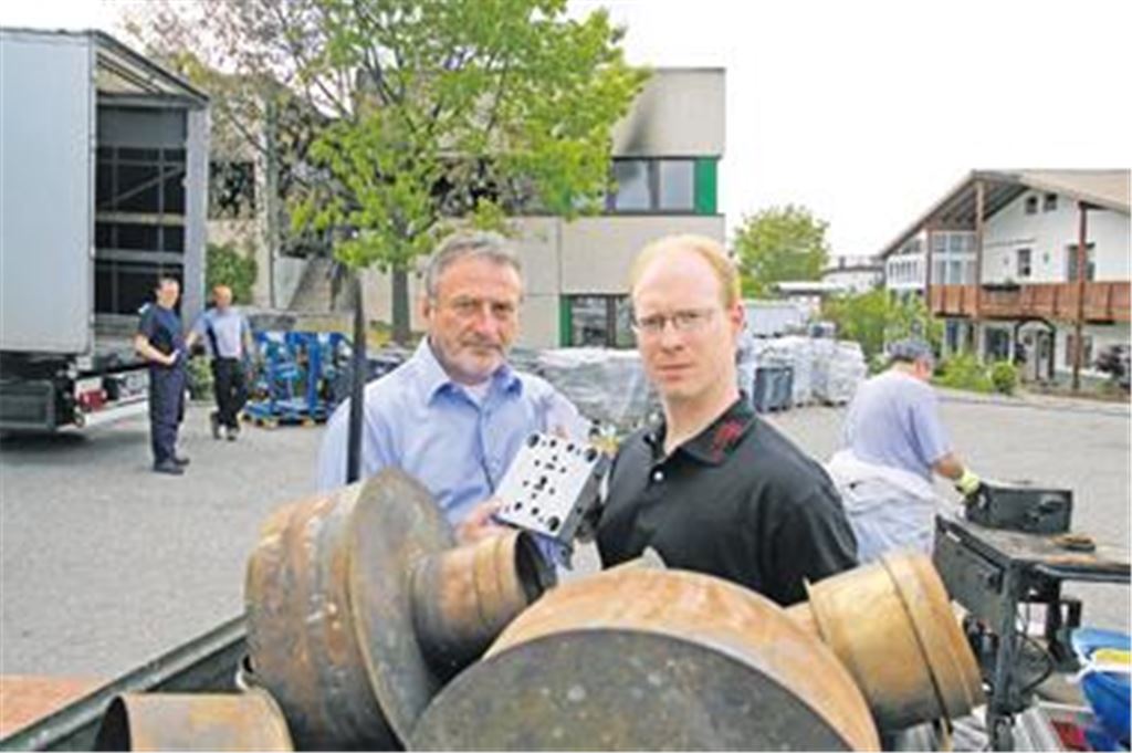 Unternehmer Bernd Nonnenmacher (li.) und sein Versicherungspartner Mark Patrick Teßmer vor der Firma in Dürrn, die von einem Feuer schwer in Mitleidenschaft gezogen wurde. Im Vordergrund warten gerettete Maschinenteile auf ihre Reinigung von den Spuren des Großbrands  nach der Behandlung durch Spezialisten sehen sie wie neu aus, wie der Firmenchef zeigen kann.
Foto: Disselhoff