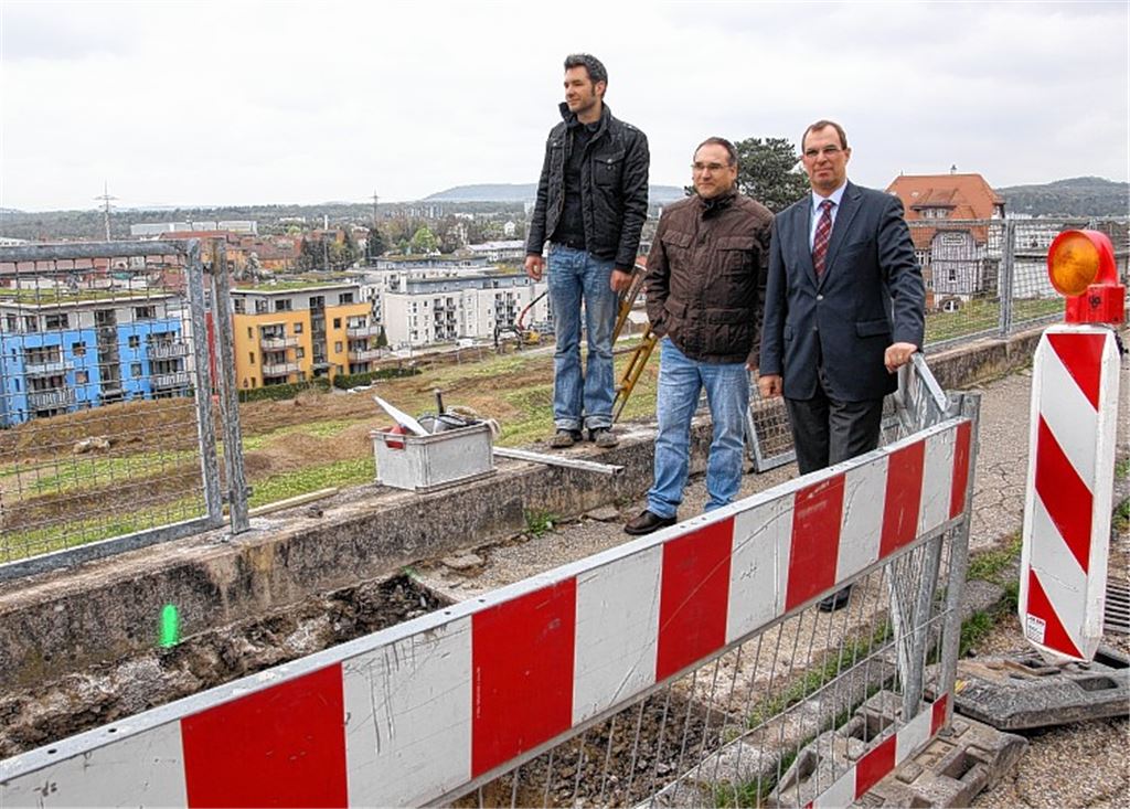 Untersuchungen zeigen, dass die Mauer, die den Gehweg an der Schillerstraße hält, nicht gegründet ist, weshalb der Bürgersteig sich „bewegt“. OB Frank Schneider, Amtsleiter Konrad Teufel und Geologe Georg Hils (v. re.) machen sich vor Ort ein Bild vom Zustand des Sporthallengeländes. 