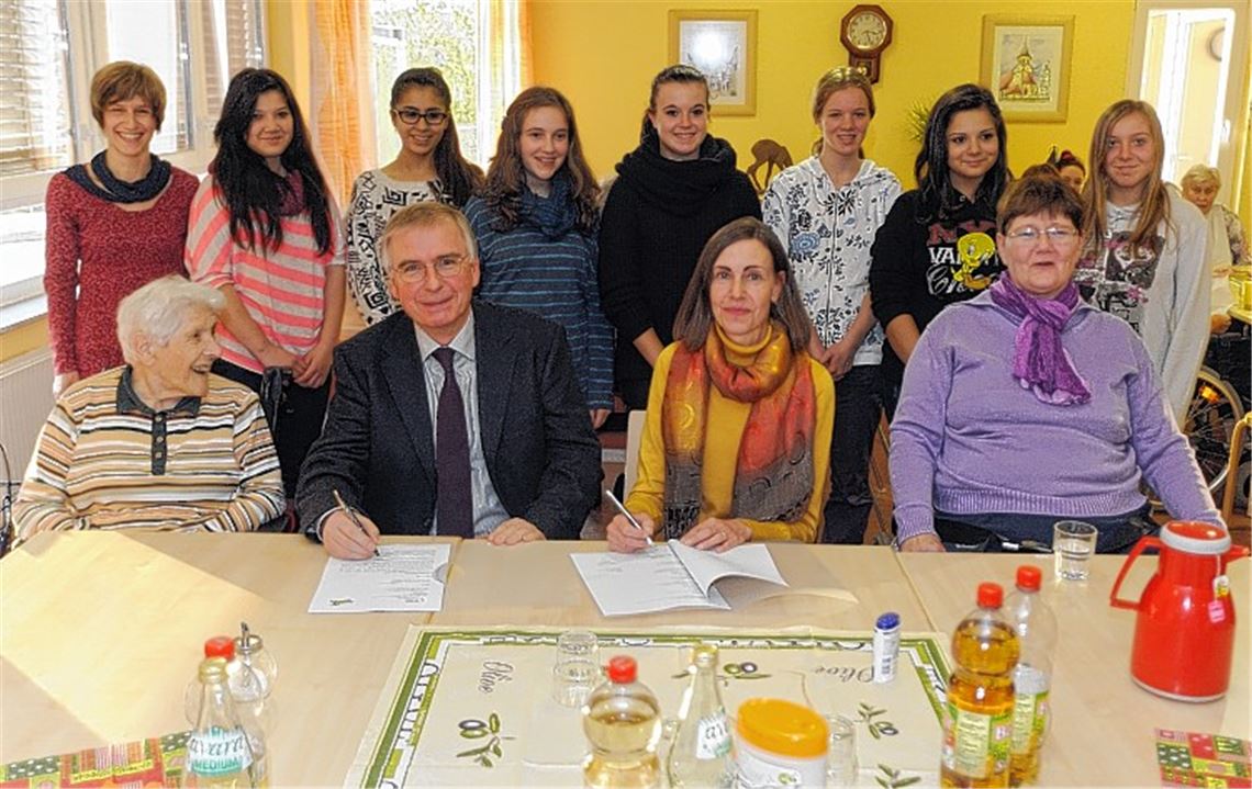 Ursula Günster und Andreas Petermann unterzeichnen im Beisein von Projektleiterin Ulrike Metzger und Schülerinnen (hinten v.li.) die Bildungskooperation.