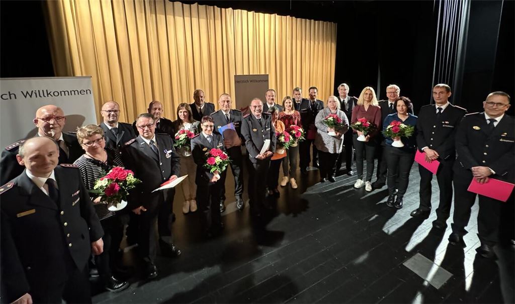 Verbandsvorsitzender Markus Haberstroh (li.) überreicht die Auszeichnungen an verdiente Feuerwehrleute und dankte auch den Partnerinnen mit einem Blumenstrauß. Foto: privat