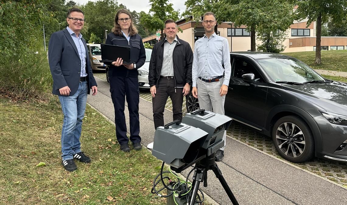 Verkehrsbehördenleiter Oliver Müller (v.li.), Außendienstmitarbeiterin Jennifer Becht, Bürgermeister Carsten Hoffmann und Ordnungsdezernent Holger Nickel informieren sich vor der Grundschule in Grunbach über die Geschwindigkeitsüberwachung zum Schulbeginn. Foto: Enzkreis/Schendel