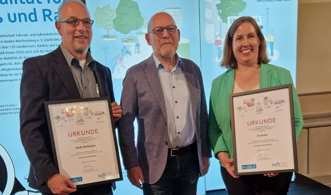 Verkehrsminister Winfried Hermann (Grüne) gratuliert dem Enzkreis, vertreten durch die Erste Landesbeamtin Dr. Hilde Neidhardt, und Jörg Soulier (li.), der für die Stadt Mühlacker an der Veranstaltung teilnimmt, zum Erreichen der „Qualitätsstufe“ im Fuß- und Radverkehr. Foto: Enzkreis/Wexel