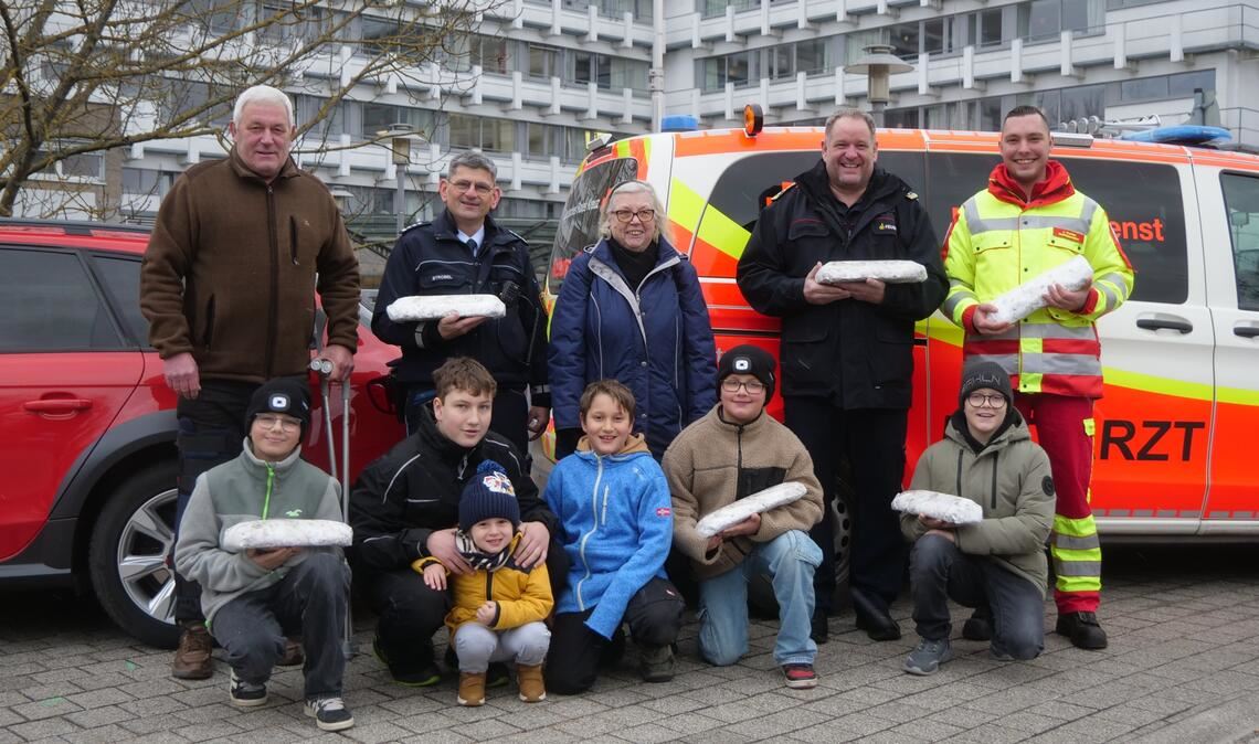 Vertreter der Verkehrswacht Mühlacker und Umgebung e.V. überreichen Mitarbeitern von DRK, Notarzt, Malteser Rettungsdienst, Feuerwehr und Polizei in Mühlacker selbstgebackene Christstollen als Weihnachtspräsent. Foto: Friedrich