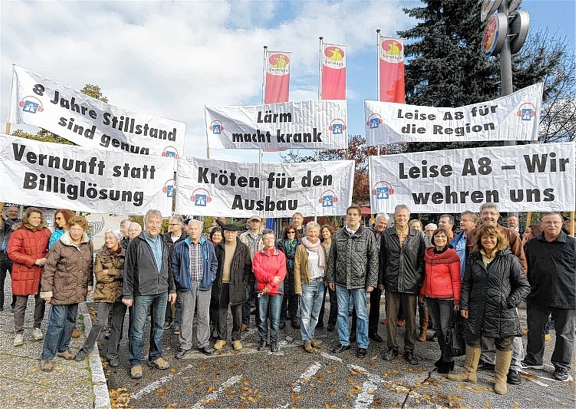 Vertreter des Gemeinderats und des Vereins „Leise A8“ demonstrieren vor der Tank- und Rastanlage für eine bessere Planung. Foto: Thilo Keller