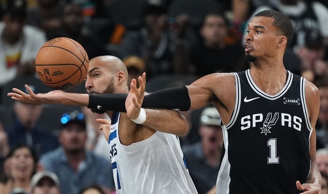 Victor Wembanyama (r) greift über Rudy Gobert (l) nach einem Rebound.