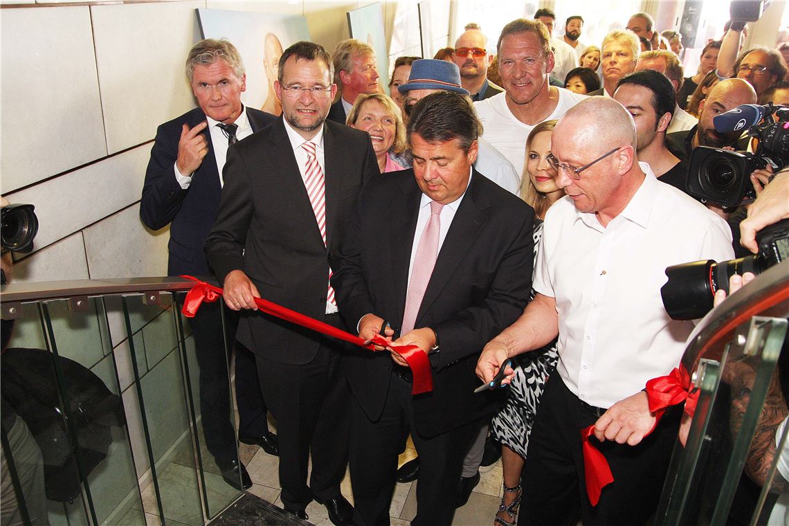 Viel Prominenz im neuen Bildungs- und Sportzentrum: Der Pforzheimer OB Gert Hager (v.li.), Vize-Kanzler Sigmar Gabriel und Uwe Hück schneiden das symbolische rote Band durch – der Weg zu Bildung und Sport steht benachteiligten Jugendlichen und Flüchtlingen an der Maximilianstraße 46 in Pforzheim von jetzt an offen. Foto: Wacker