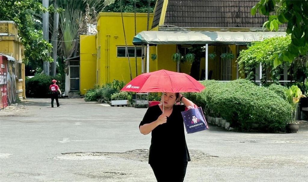 Viele schützen sich mit Schirmen vor der Sonne.