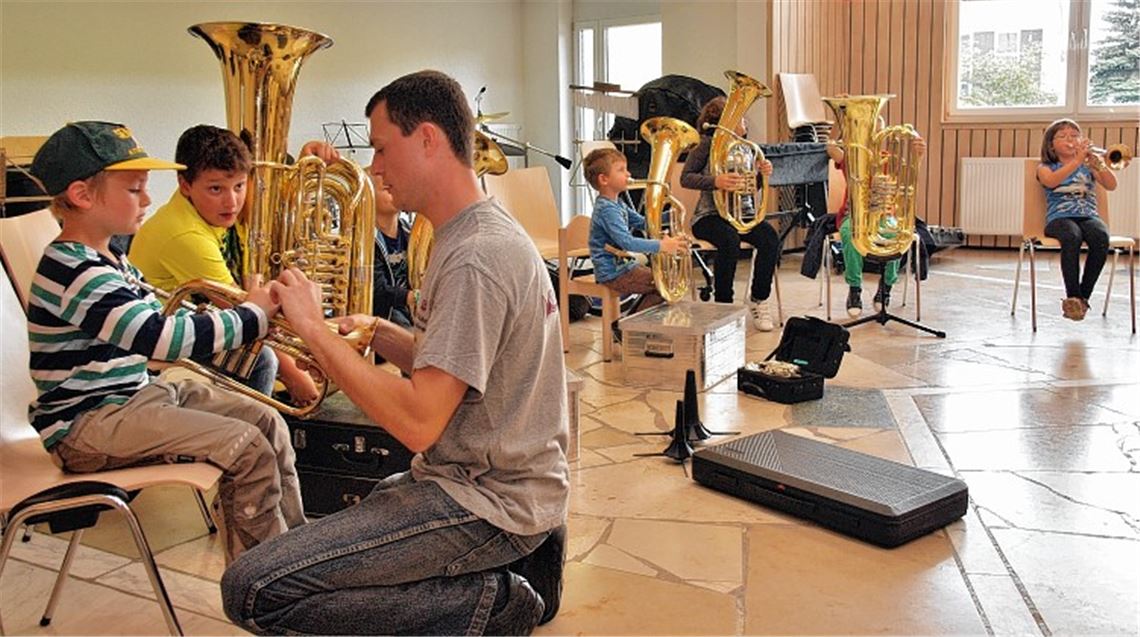 Volker Duss weist Kinder in die Geheimnisse von Blechblasinstrumenten ein. Foto: Appich