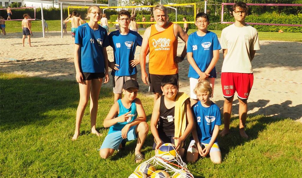 Volleyballtrainer Jürgen Schmidt (stehend, Mitte) freut sich mit teilnehmenden Jugendlichen auf das weitere Beachvolleyball-Ferienprogram des Turnvereins Mühlacker.