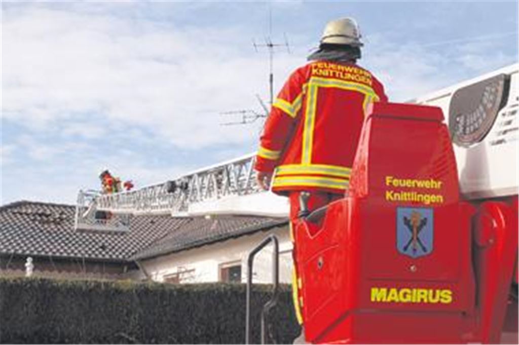 Von der Drehleiter aus wird eine Teilfläche des Daches durch die Feuerwehr abgedeckt.
Foto: Franz