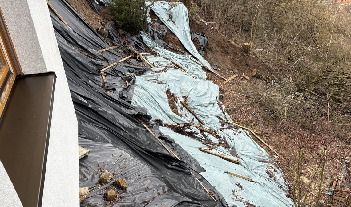 Von einem Hangrutsch  in Schwäbisch Gmünd sind drei Häuser betroffen. Mit einer riesigen Plane versuchen die Eigentümer das Wasser abzuleiten – als kurzfristige Maßnahme.