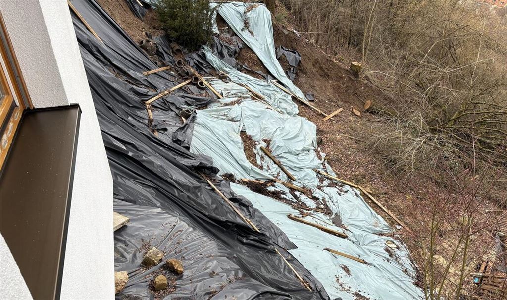 Von einem Hangrutsch  in Schwäbisch Gmünd sind drei Häuser betroffen. Mit einer riesigen Plane versuchen die Eigentümer das Wasser abzuleiten – als kurzfristige Maßnahme.