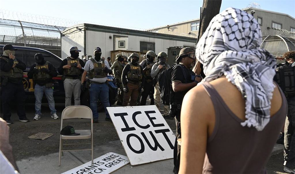 Vor Bundesbeamten der Einwanderungsbehörde ICE haben Demonstrierende ein großes Schild mit der Aufschrift "ICE out" drapiert.
