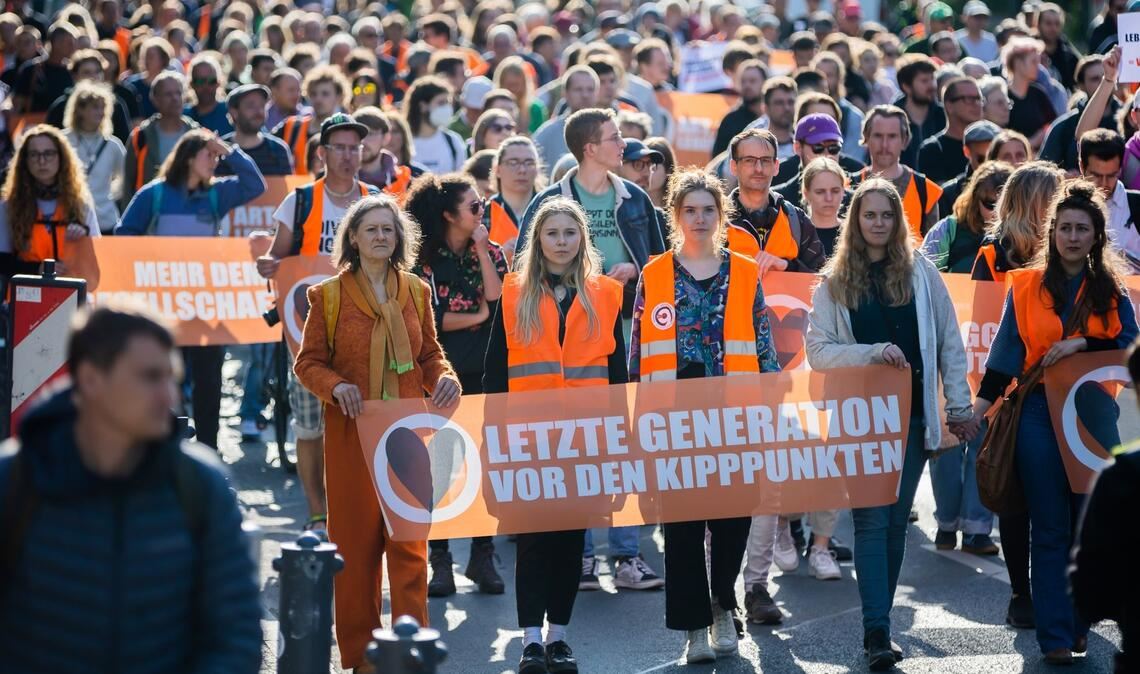 "Vor den Kipppunkten" - Die Klimaaktivisten der letzten Generation demonstrieren auf der Straße des 17. Juni in Richtung Brandenburger Tor.
