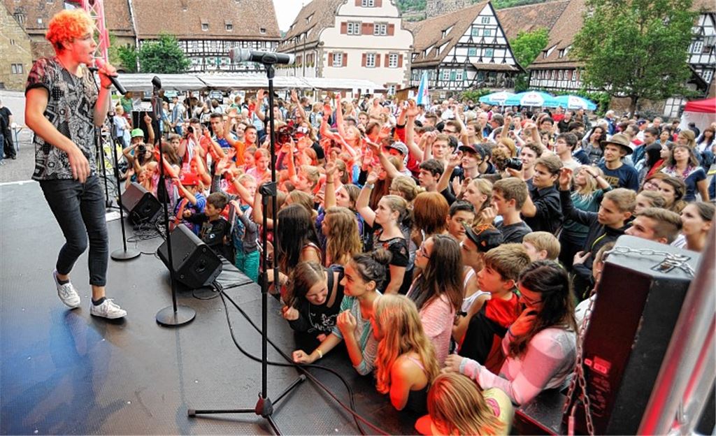 Vor der Bühne im Klosterhof gehen die Besucher von Anfang an mit, wie hier beim Auftritt von Rapper Mclu (Lukas Stütz). Foto: Fotomoment