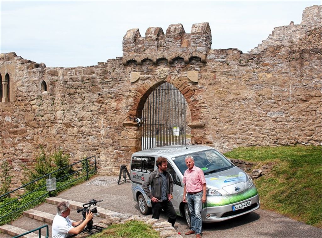 Vor der Kulisse der Burgruine Löffelstelz: Nissan-Dreharbeiten zum Thema Elektromobilität mit dem elektrisch angetriebenen Löffelstelz-Shuttle. Vor dem Fahrzeug Thomas Knapp (re.) im Gespräch mit Produktionsleiter Peter Kröninger, links: Kameramann Karsten Raduenz. Foto: Kollros