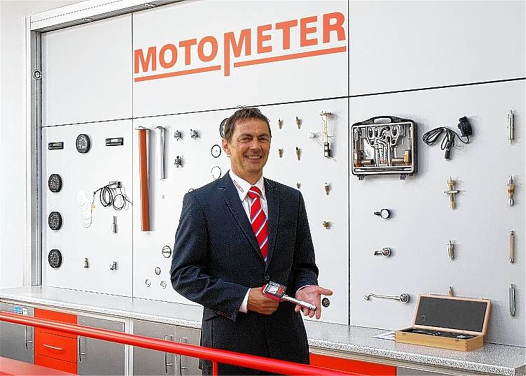 Vor einer Wand mit Produkten präsentiert Geschäftsführer Joachim Bulla die Jubiläumsedition eines Kompressionsdruckprüfers, des Klassikers von Motometer. 