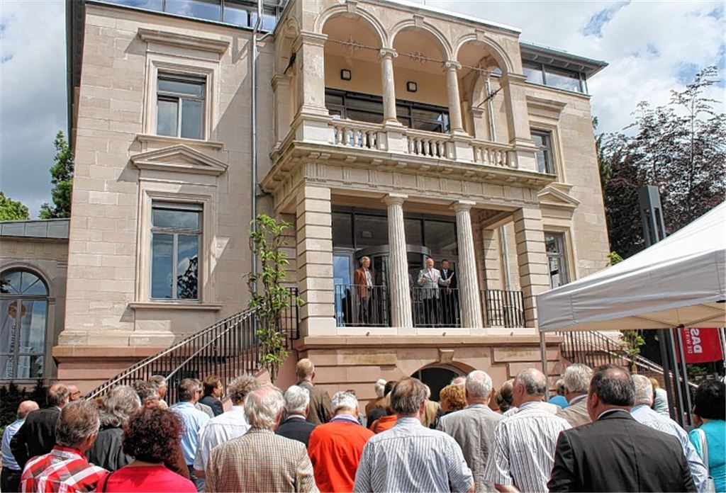 Vorher, nachher: Nicht schlecht staunen die Besucher, darunter der Bundestagsabgeordnete Memet Kilic (Mitte), als ihnen Architekt Thomas Dressel die Fotos von vor der Renovierung zeigt