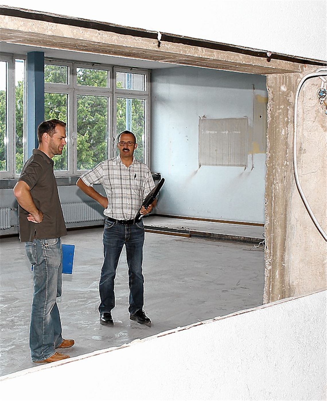 Vorn waren Ausstellungsvitrinen und dahinter Einbauschränke – da hätte sich ein Feuer leicht ausbreiten können, sind Wolfgang Thümmel (re.) und Jochen Bauer vom Enzkreis-Gebäudemanagement überzeugt (Bild li.). Hinter dieser Schleuse mit Abluftabsaugung erfolgt die Entfernung schadstoffhaltiger Materialien wie Bodenbeläge mit asbesthaltigem Kleber.