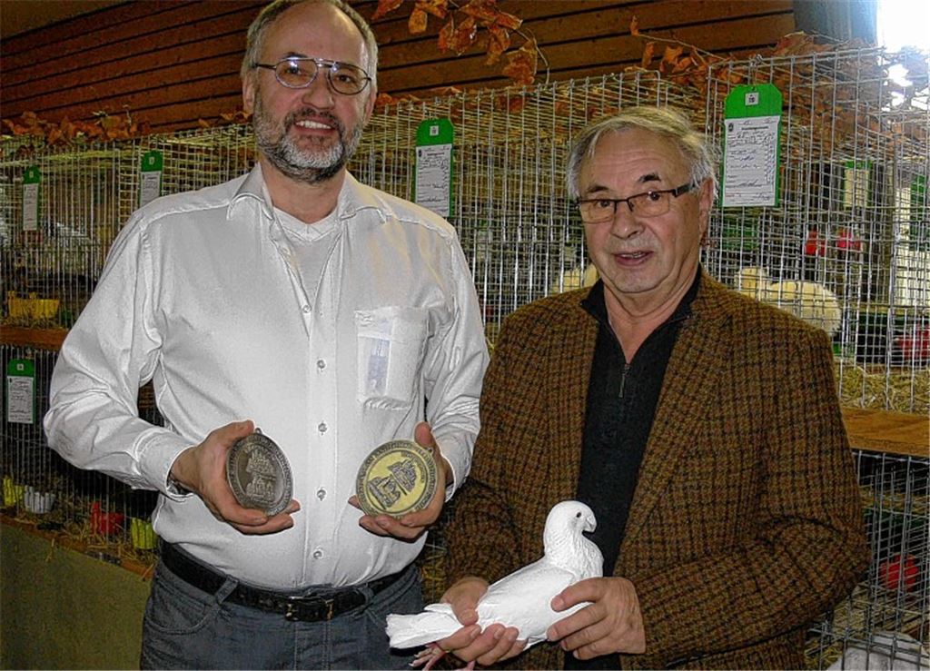 Vorsitzender Peter Aranyossy (li.) gratuliert Jürgen Holtz zu seinen Erfolgen als Züchter von Deutschen Schautauben.