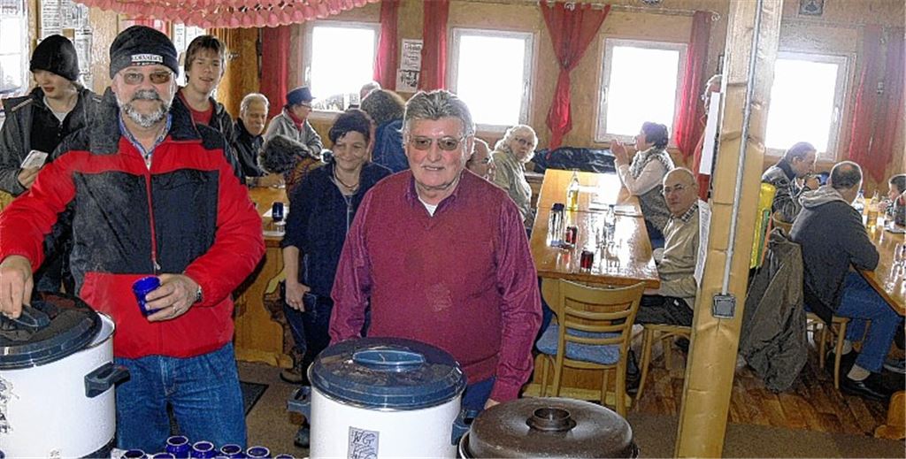 Vorsitzender Tilo Pürmeyer (re.) und sein Vize, Dr. Hans-Jürgen Pauling, schenken den Gästen im „Adlerhorst“, dem Vereinsheim der Bogenschützen, Glühwein ein. Foto: Garhöfer
