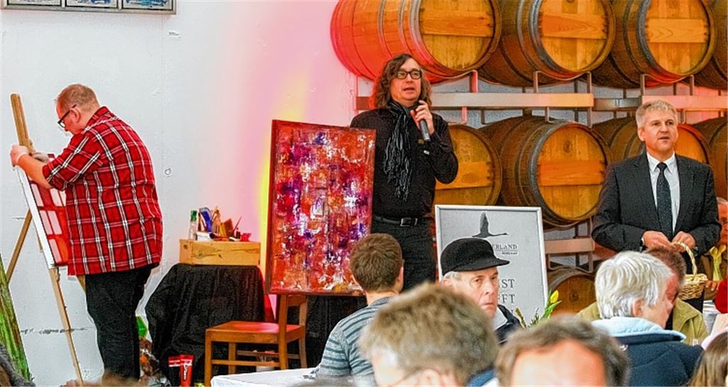 Während Harry Klenk (li.) malt, versteigert Genossenschafts-Geschäftsführer Bertram Haak (Mitte) Klenks Bilder. Vaihingens Oberbürgermeister Gerd Maisch sammelt das Geld ein. 