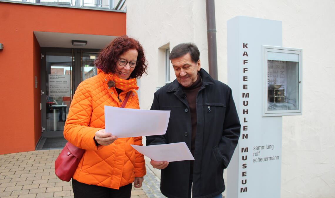 SWR-Dreh: Kaffeemühlen treten gegen Staubsauger an Während Theresa Ostwald und Rainer Zundel ein Bild im Ort finden müssen, stellt TV-Moderator Jens Hübschen (Foto unten im Text mit der roten Jacke) den Passanten Quizfragen. Die Konkurrenz in Bruchmühlbach-Miesau erwartet das gleiche Prozedere. Fotos: Steigleder