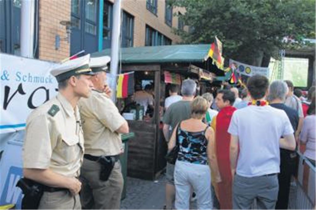 Während andere das Spiel genießen können, sorgt die Polizei mit zusätzlichen Beamten für Sicherheit bei den Publik Viewing-Veranstaltungen. In Mühlacker hat Polizeichef Udo Buchholz (li.) und sein Stellvertreter Siegfried Albrecht ein Auge auf den Bierstand. Kinder sollen damit abgeschreckt werden, alkoholische Getränke zu kaufen. Foto: Franz