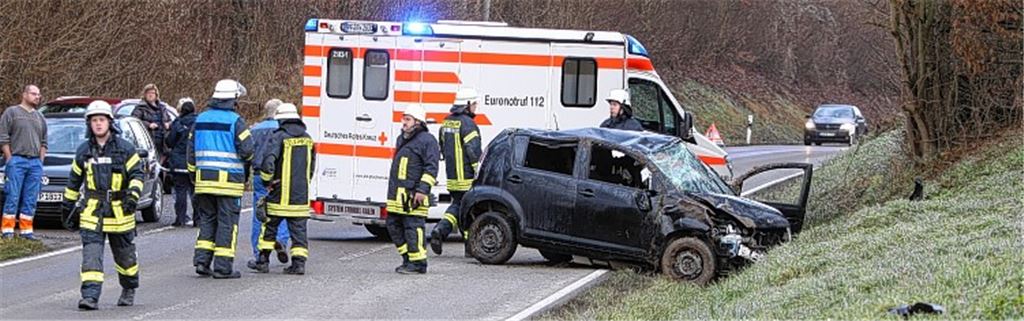 Während die verunglückte Fahrerin des Daihatsu im Krankenwagen medizinisch versorgt wird, reinigt die Illinger Feuerwehr die Straße.  Foto: Disselhoff
