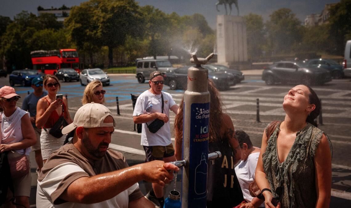 Während einer Hitzewelle in Paris suchen Menschen an einem Nebelbrunnen auf der Place du Trocadéro Abkühlung.