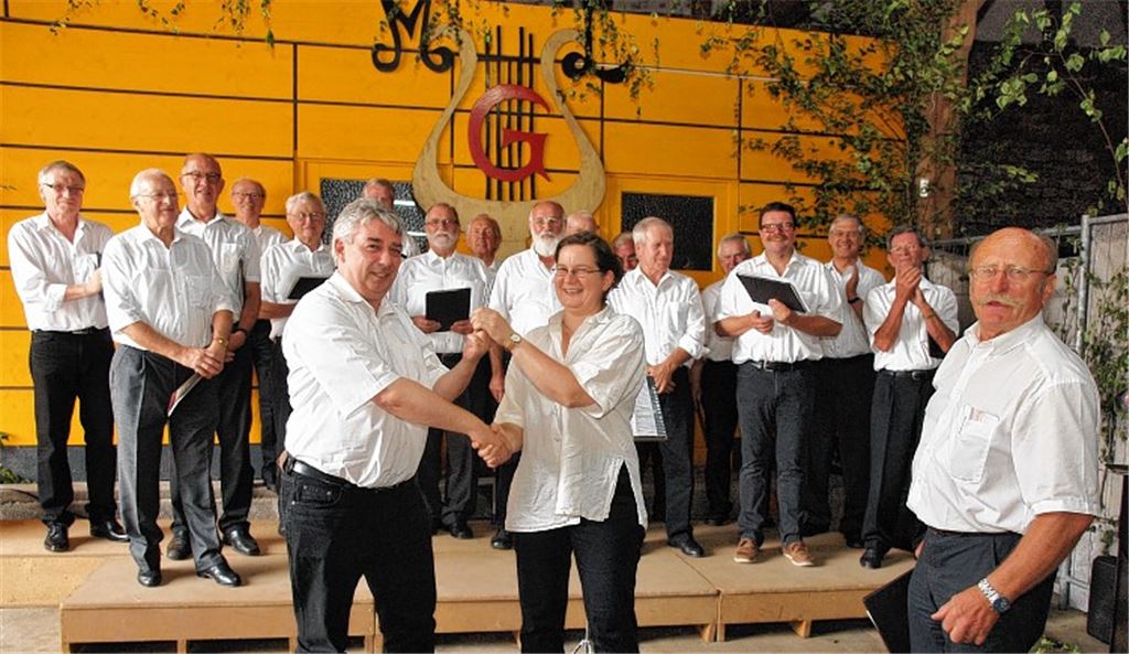 Walter Klisa übergibt nach 16 Dirigentenjahren die Stimmgabel an Beate Rau. Rechts auf dem Bild: Liederkranz.-Vorsitzender Dieter Zaremba. Foto: Appich