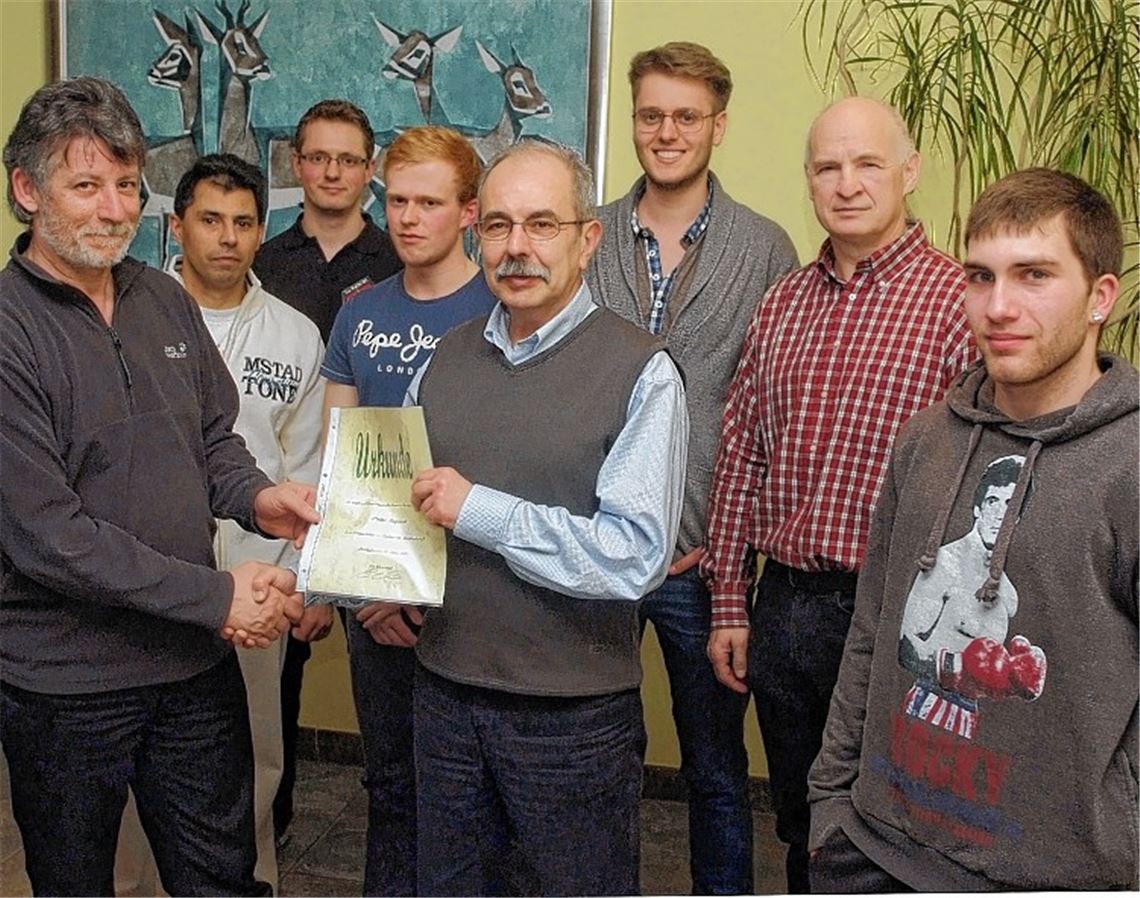 Walter Ruppert (Mitte) wird zum Ehrenmitglied ernannt. Sportwart Thomas Kreutz, Ruben Weiler (Leiter der Abteilung Ju-Jutsu), der Zweite Vorsitzende Tizian Klingel, der Erste Vorsitzende Luis Escolano, Pressewart Gerrit Heilmann, Kassier Enrico Simon und der neue stellvertretende Pressewart Florian Gulyas (v. li. ) bilden das neue Vorstandsgremium von Taekwondo Mühlacker. Foto: Fotomoment