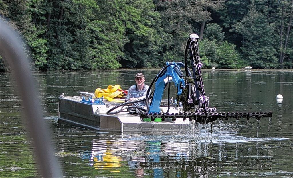 Wasser trieft von der absenkbaren Riesenschere des Mähboots, die gerade noch unter der Oberfläche gegen das Grünzeug im Maulbronner Naturfreibad gekämpft hat. Foto: Disselhoff