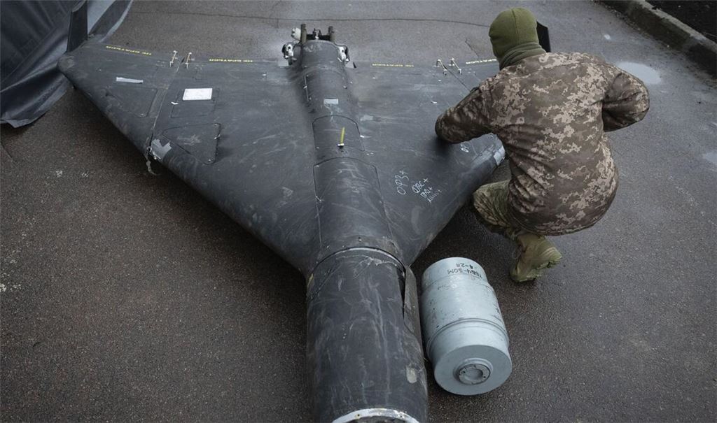 Weltweit führende Experten: ein ukrainischer Soldat untersucht bei Kyjiv eine abgeschossene russische Shahed-Drohne iranischer Bauart.