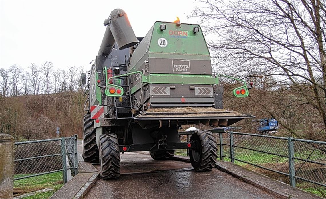 Wenig Platz für sperrige Fahrzeuge: Der Mühlhäuser Landwirt Benjamin Schmierer lässt einen Mähdrescherfahrer demonstrieren, wie eng es auf der Brücke über die Enz zugeht. Foto: Sadler