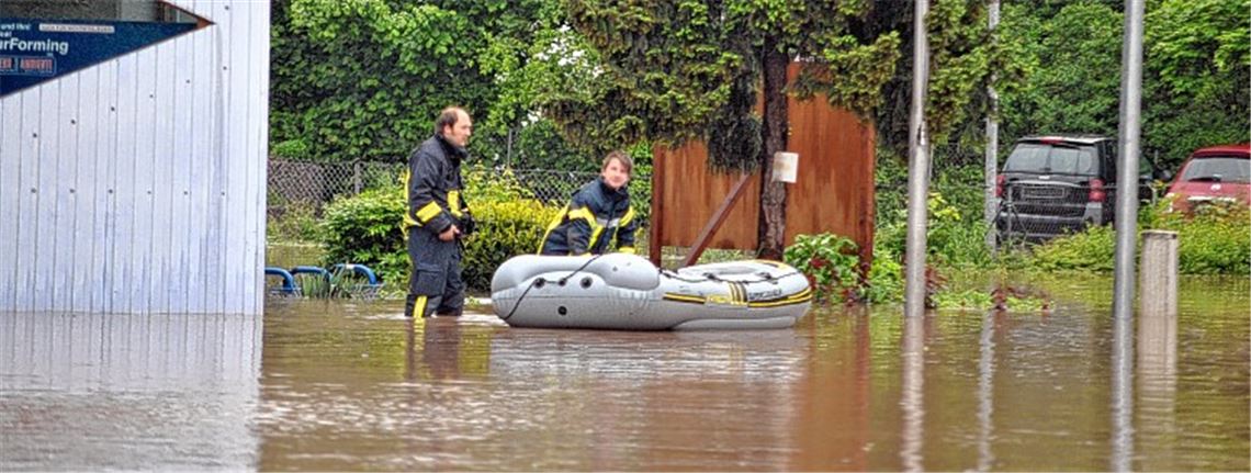 Wenn das kein Notstand ist: Feuerwehrleute kämpfen sich mit dem Schlauchboot durch die Fluten im Illinger Ortskern.