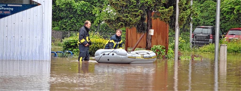 Wenn das kein Notstand ist: Feuerwehrleute kämpfen sich mit dem Schlauchboot durch die Fluten im Illinger Ortskern.