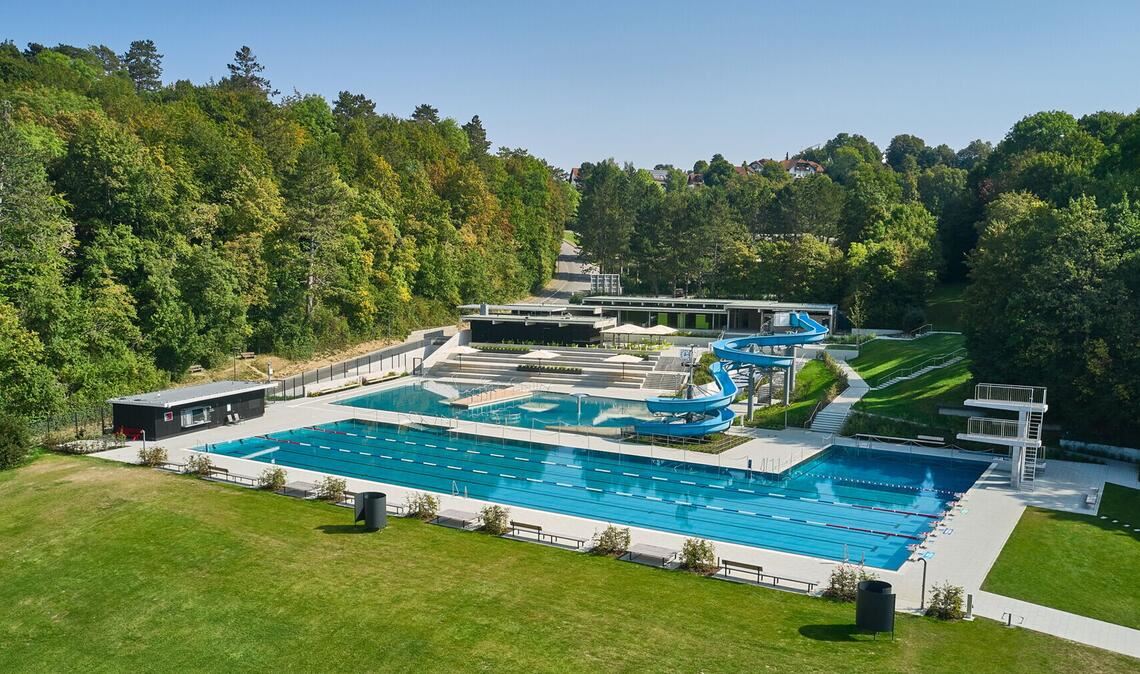 Wer nicht bis an den Bodensee möchte – 4a Architekten haben außerdem in Sigmaringen ein am Hang liegendes 60er Jahre Freibad saniert - die schönen Bäume durften freilich bleiben. Adresse: Roystraße 31, 72488 Sigmaringen. Geöffnet hat das Bad täglich ab 9 Uhr. Frühschwimmen ist von montags bis freitags von 7 bis 9 Uhr möglich