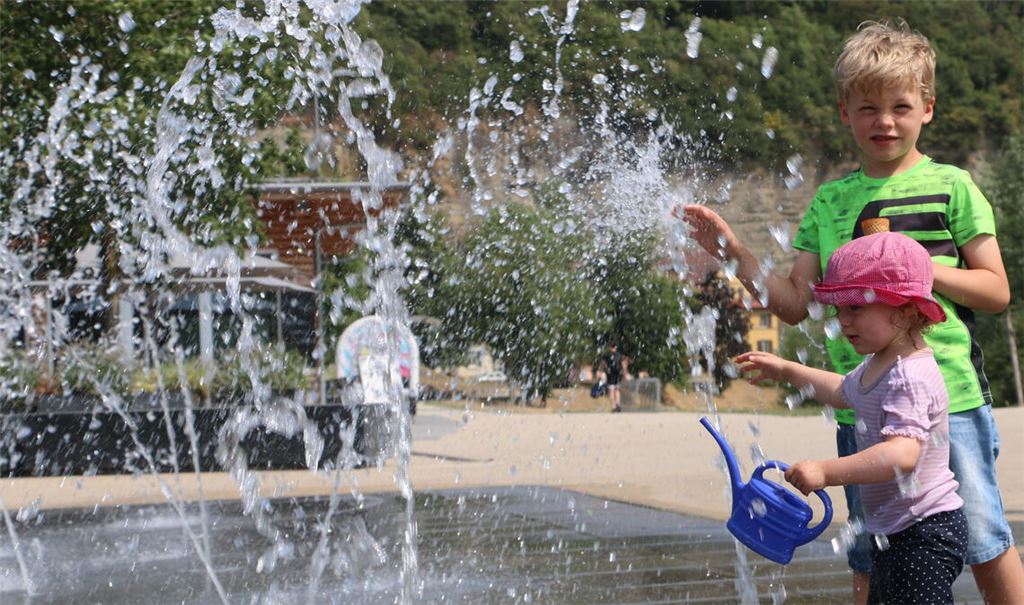 Wie man mit der Hitze klarkommt, zeigen diese Geschwister aus Illingen am Montag, die sich an den Wasserfontänen in den Mühlacker Enzgärten eine Abkühlung verschaffen. Foto: Disselhoff