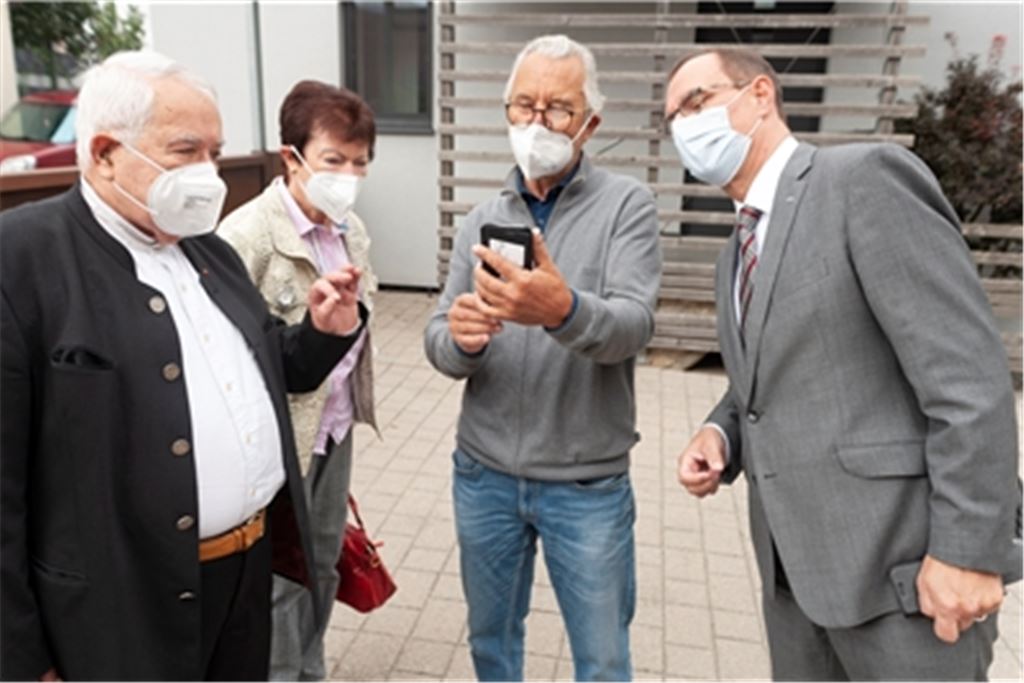 Wie wird die Büste aussehen? Noch steht sie in der Gießerei, doch Kurt Tassotti lässt OB Frank Schneider (re.), Hans A. Hey, den Ehrenpräsidenten der Gottlob-Frick-Gesellschaft (li.), und dessen Frau Ingrid via Smartphone einen Blick auf das Kunstwerk werfen. Die Bronze wird ihren Platz vor der Sparkasse in der Mühlacker Bahnhofstraße finden. Fotos: Fotomoment